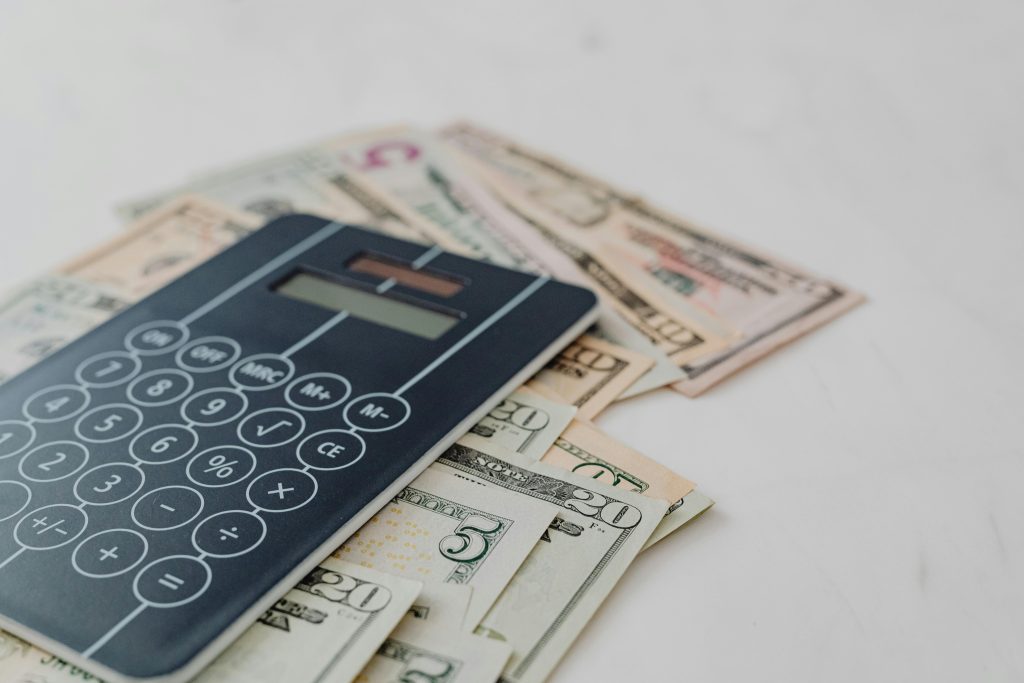 Black Calculator on top of Banknotes