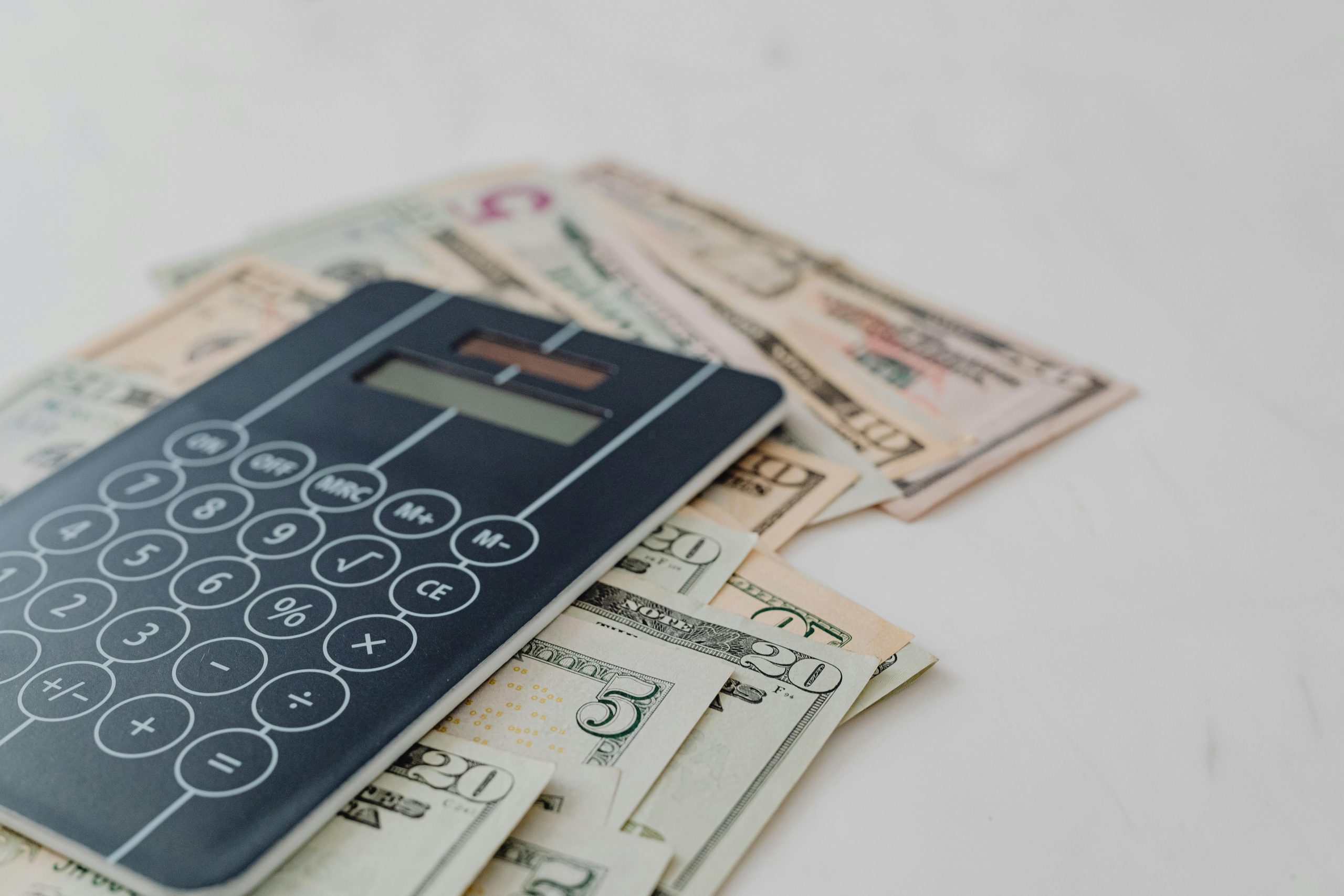 Black Calculator on top of Banknotes
